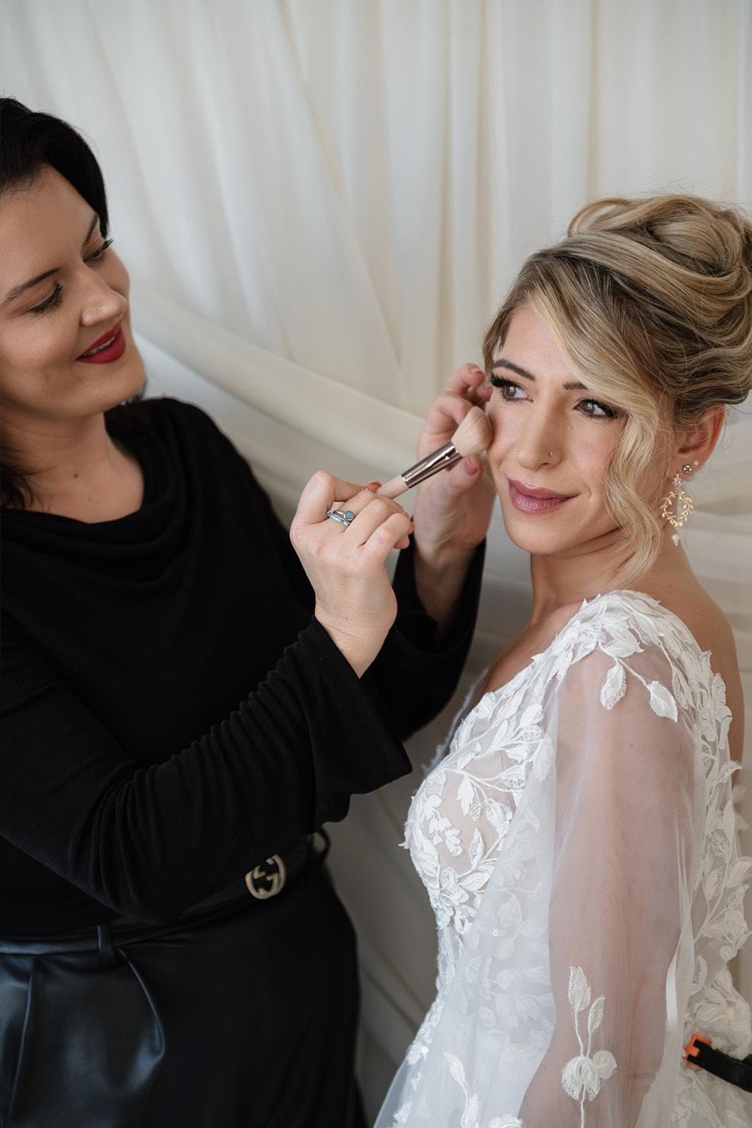 Becky applying soft glam makeup to a bride