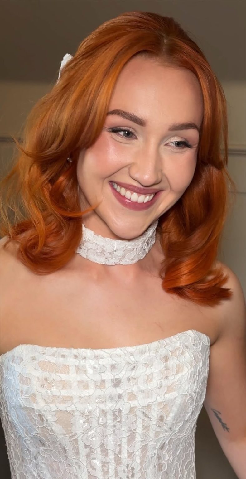 Smiling bride with copper hair and radiant, glowing bridal makeup